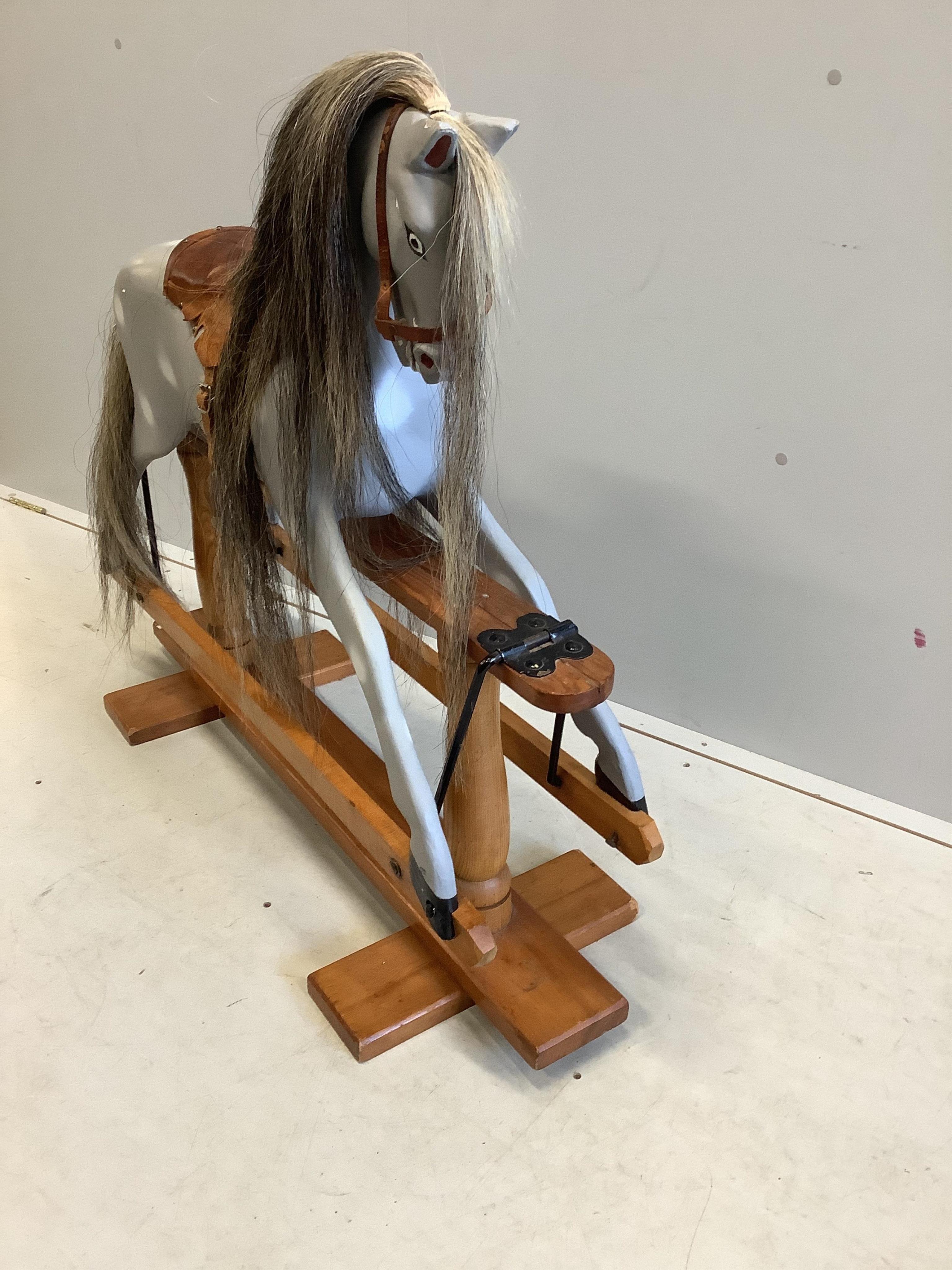 A small 1950's Ayers type dapple grey rocking horse on pine safety frame, later painted, width 106cm, height 95cm. Condition - fair